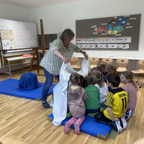 die Kinder werden unter einer weißen Decke zu Krokodileiern
