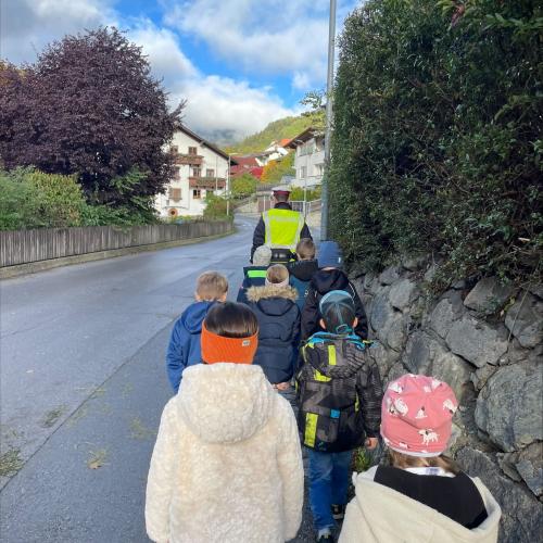 Kinder auf Gehsteig mit Polizist