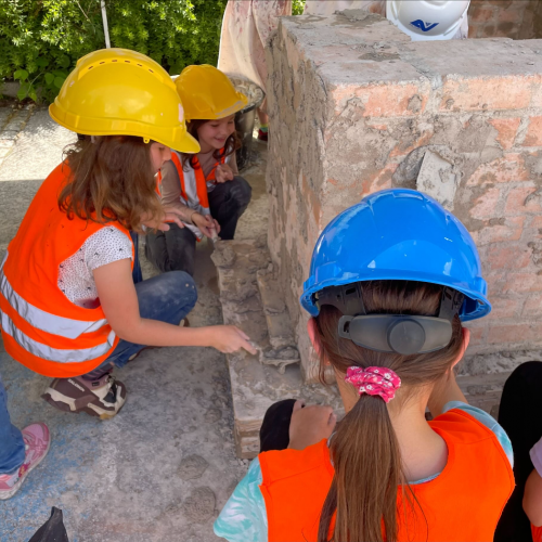 Kinder beim Mörtelauftragen